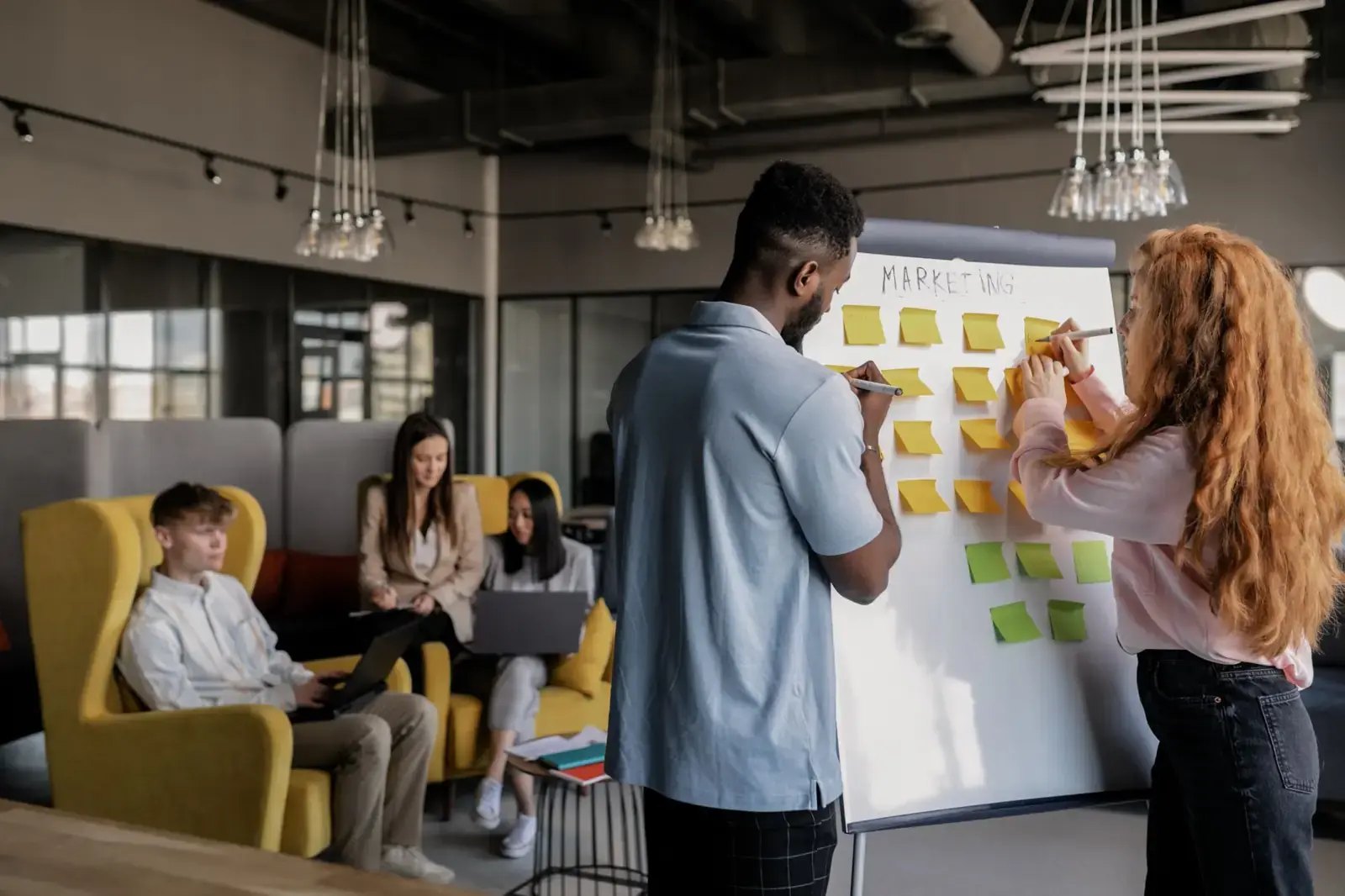 Two people planning with sticky notes on a whiteboard
